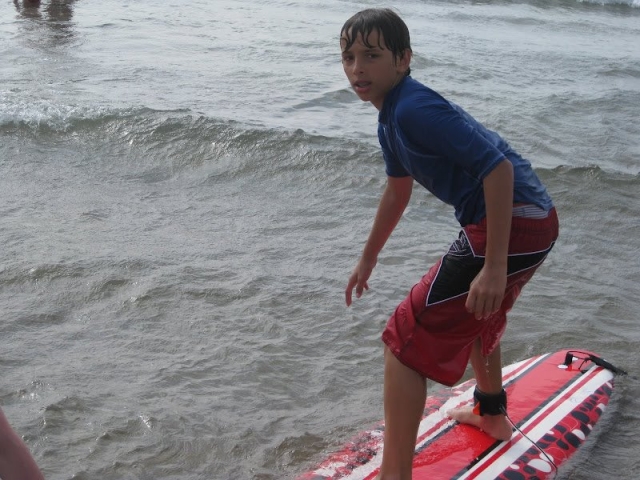 nino surfeando en una tabla roja